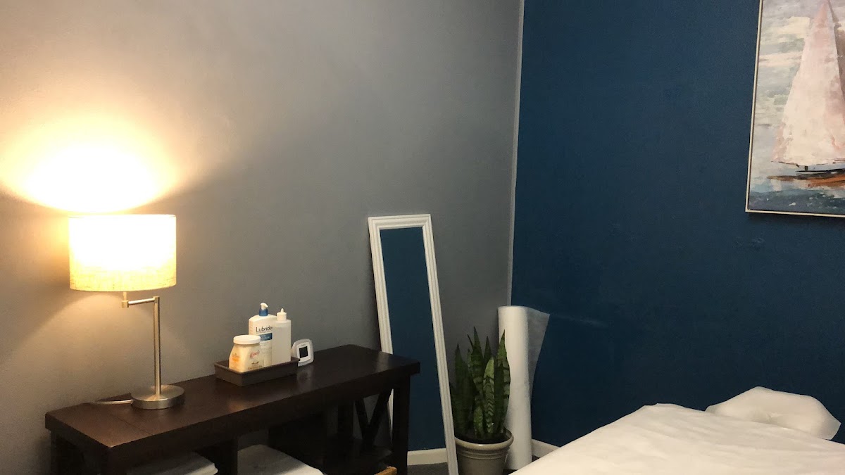 A private massage room at A+ Massage with a warm lamp and fresh linens